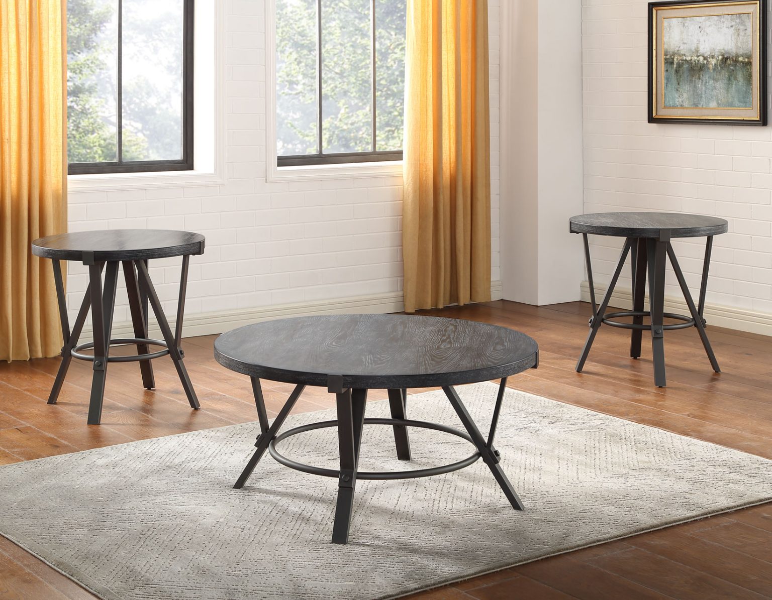 Portland occasional table collection featuring a round cocktail table and two matching end tables with black wood tops and industrial metal bases.